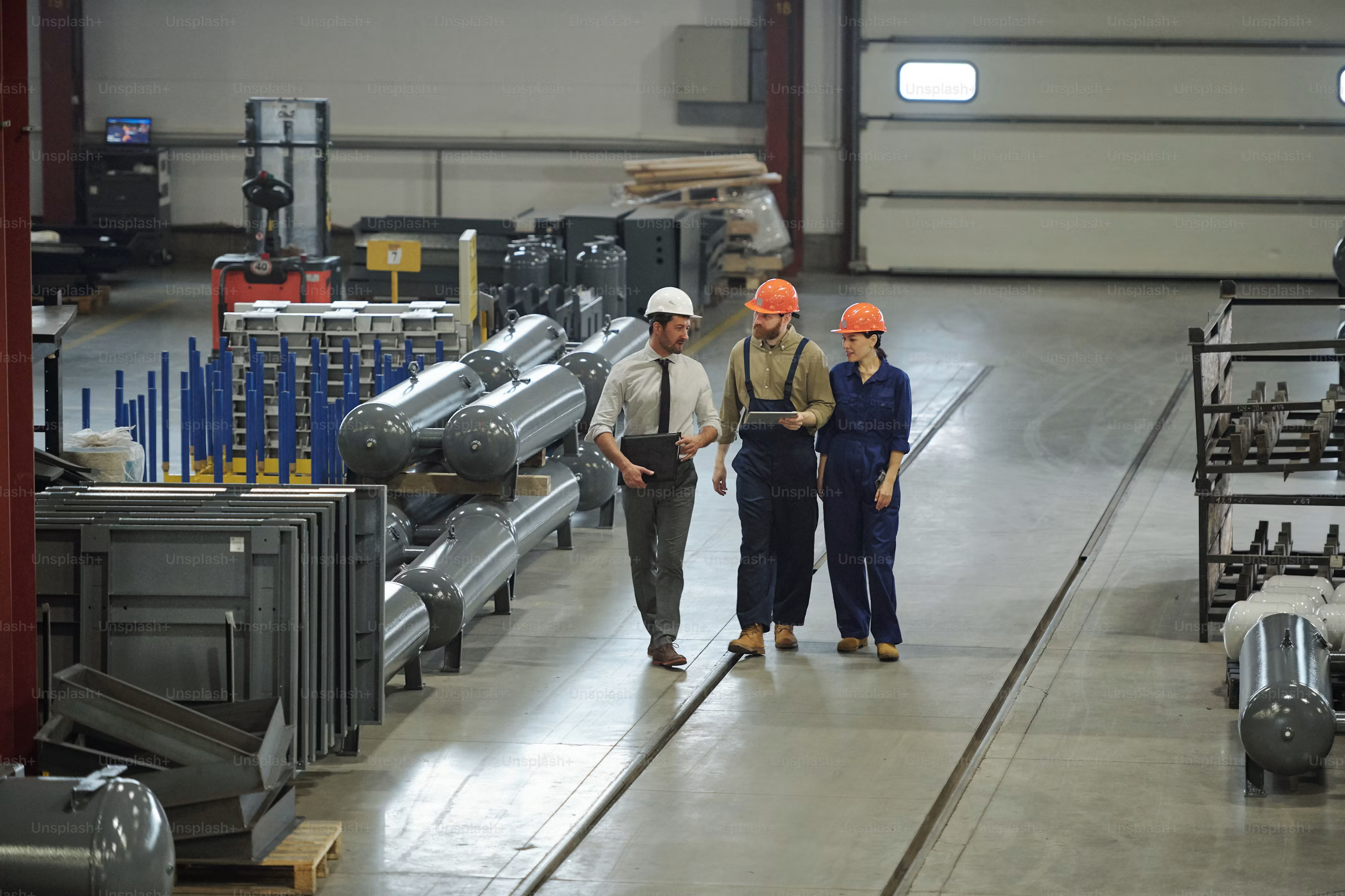 Engineers and plant workers walking through an industrial facility